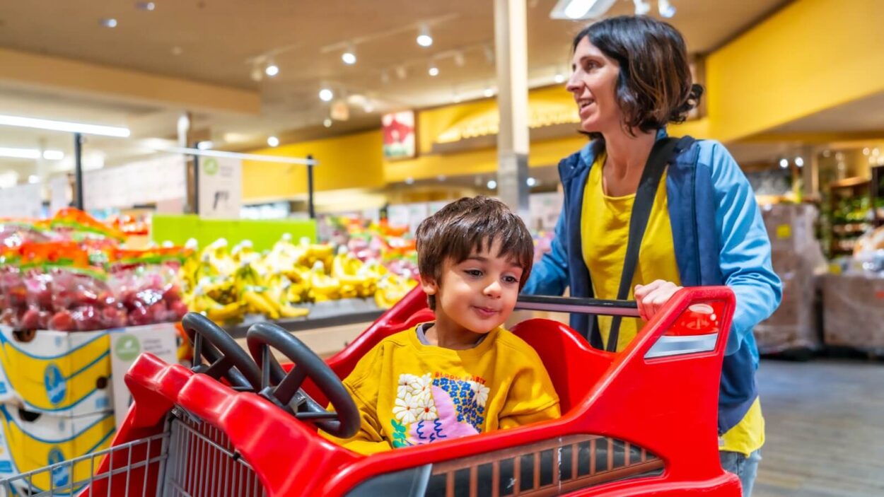 adult pushing child in red cart
