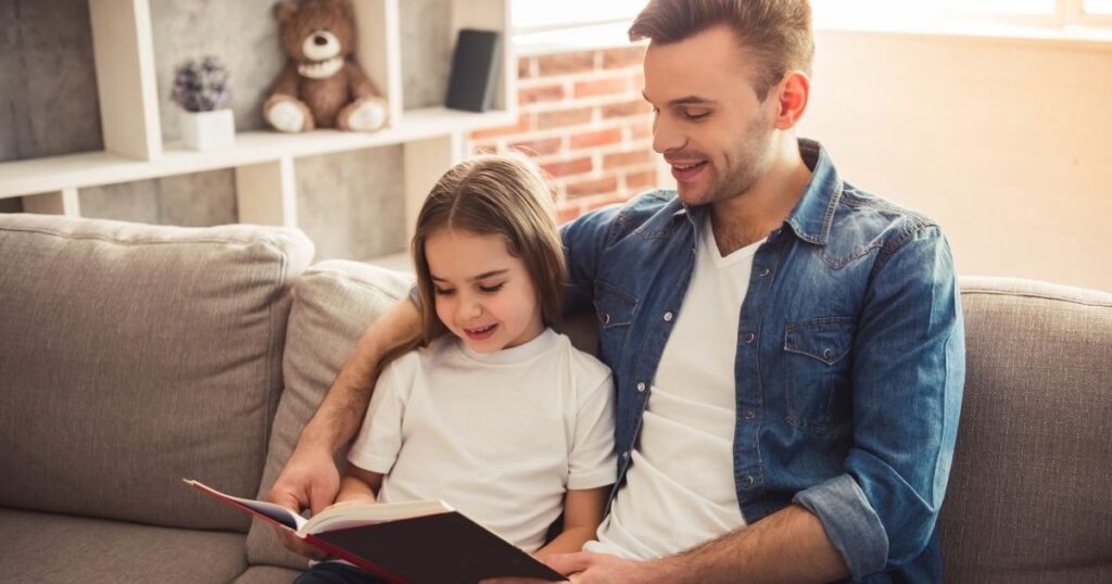 Children reading book with parent
