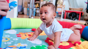 Baby sitting on a play pad