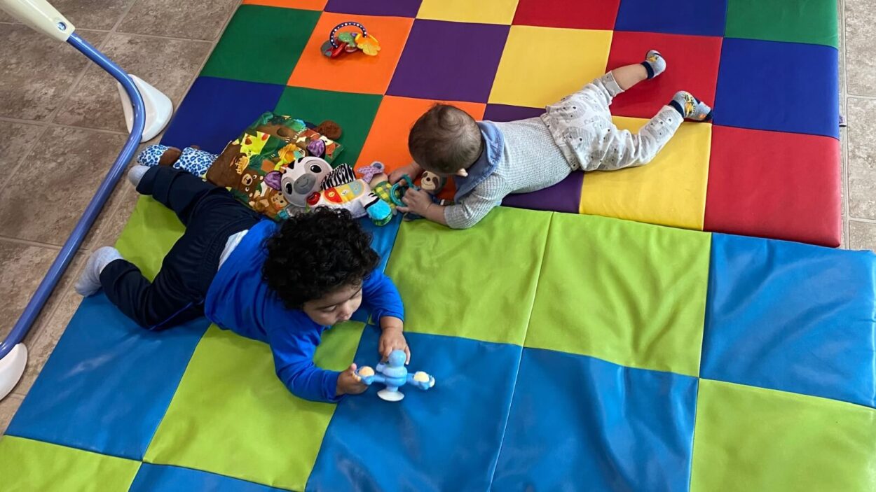 Kids crawling around a mat
