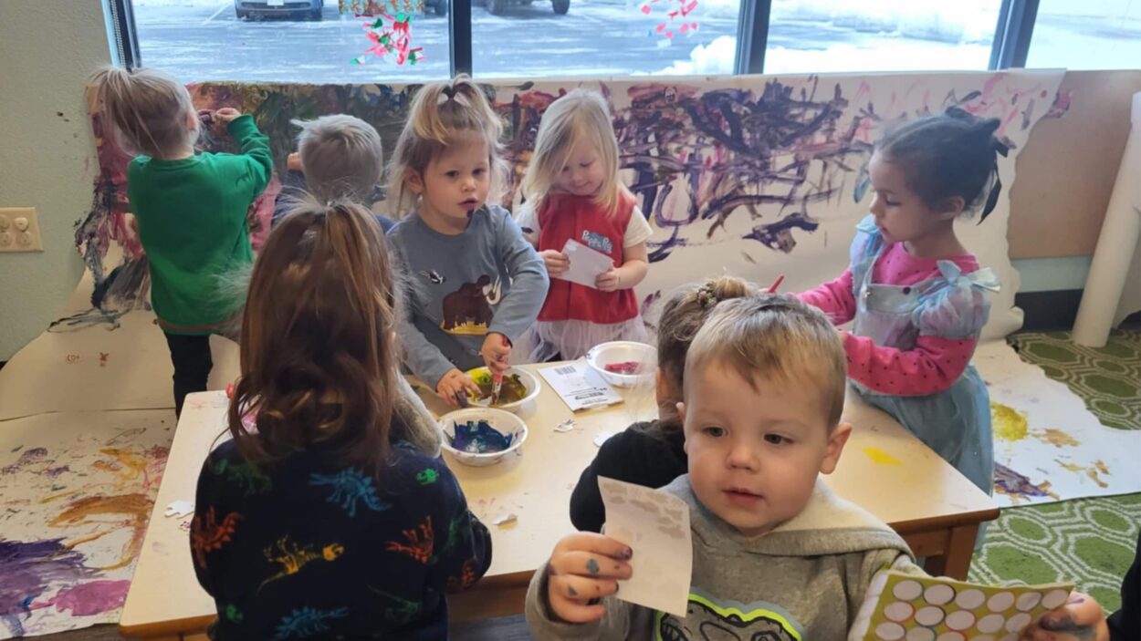 kids finger painting at a table