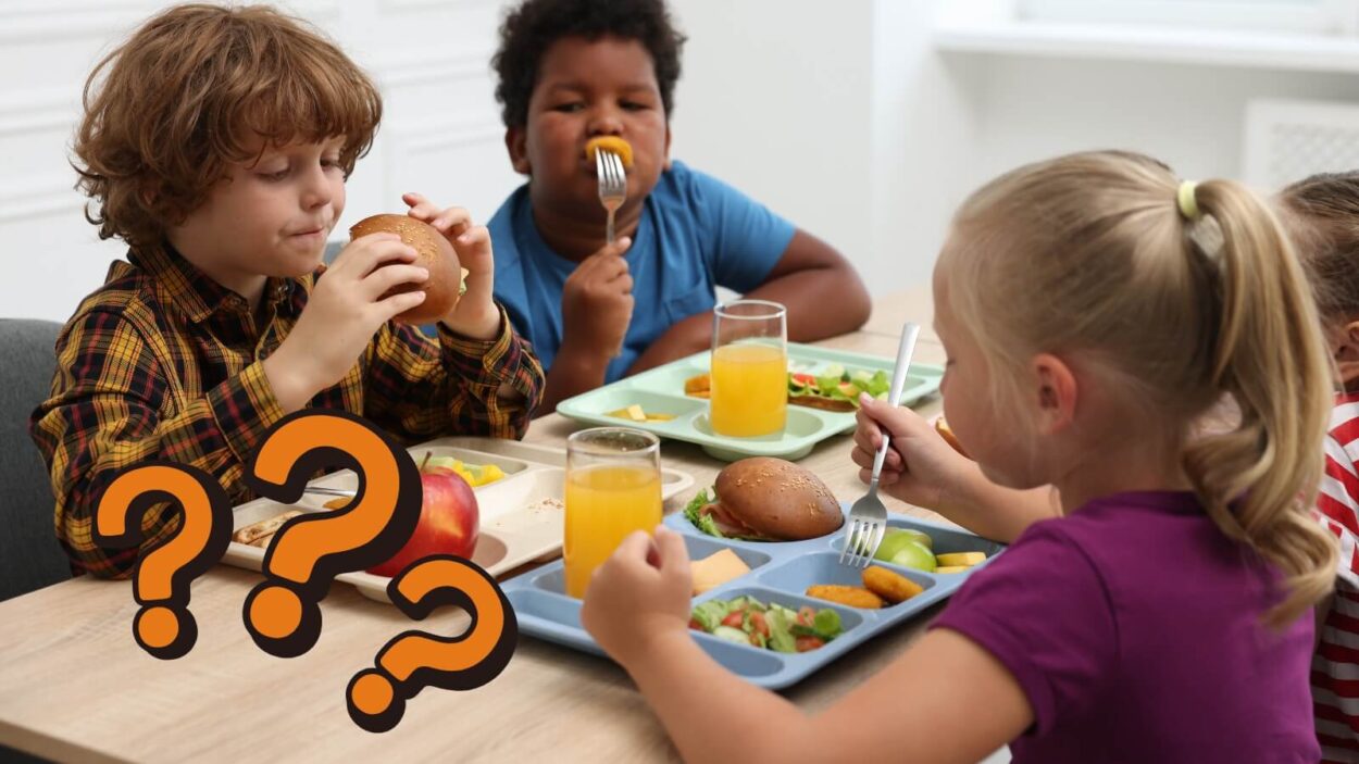 three kids sitting at a table eating lunch