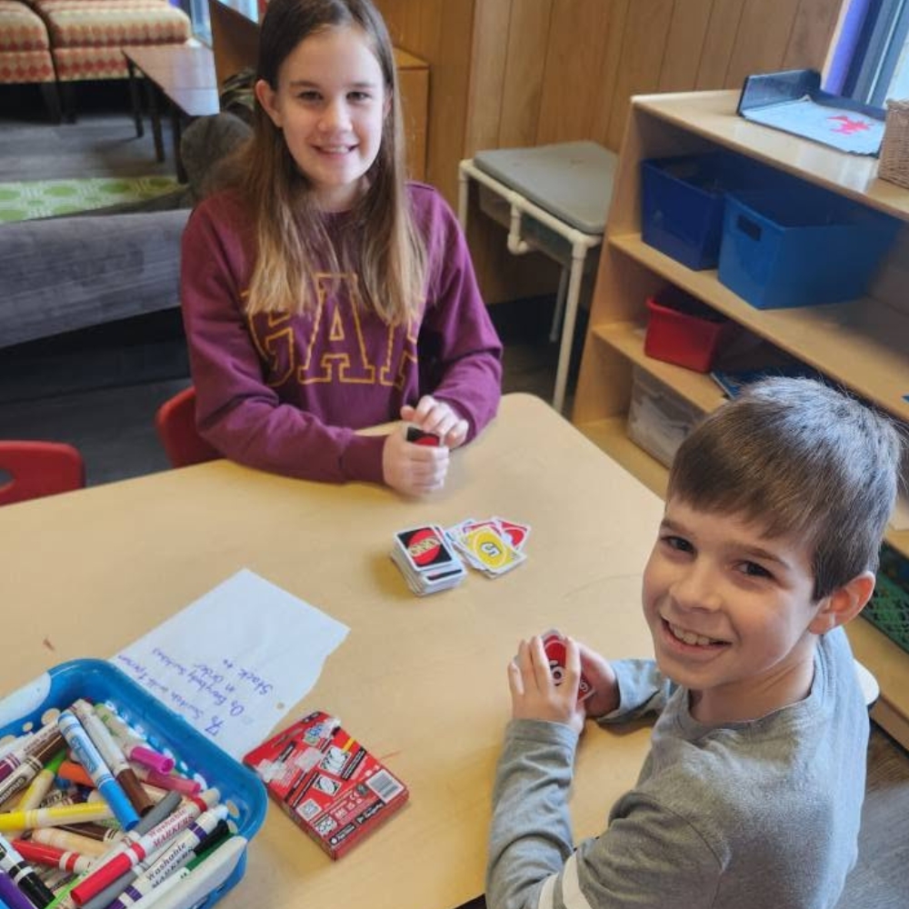 School age kids playing cards at the after school program.