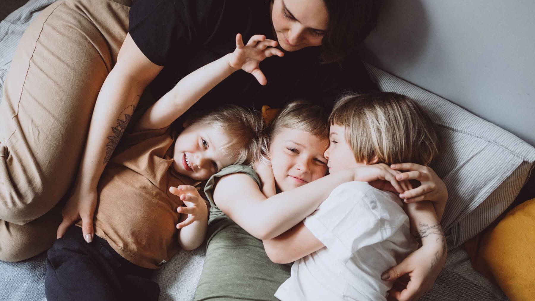 three children cuddling up with woman