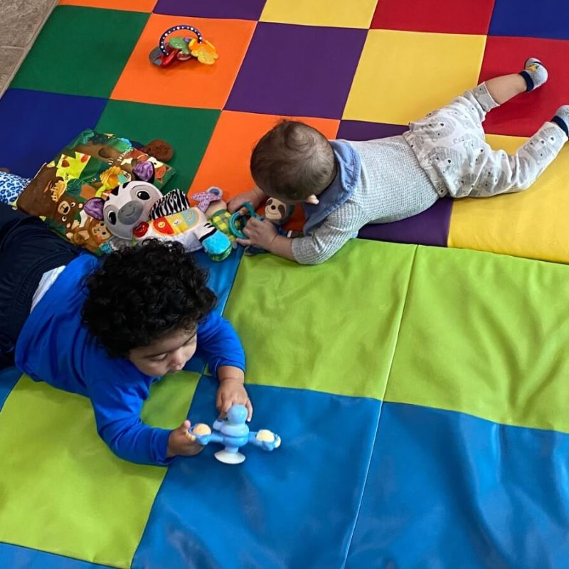 Kids crawling around a mat
